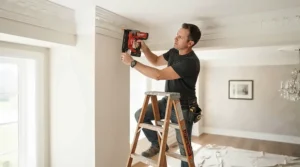 Installing decorative crown moulding on a high ceiling using a cordless finish nailer